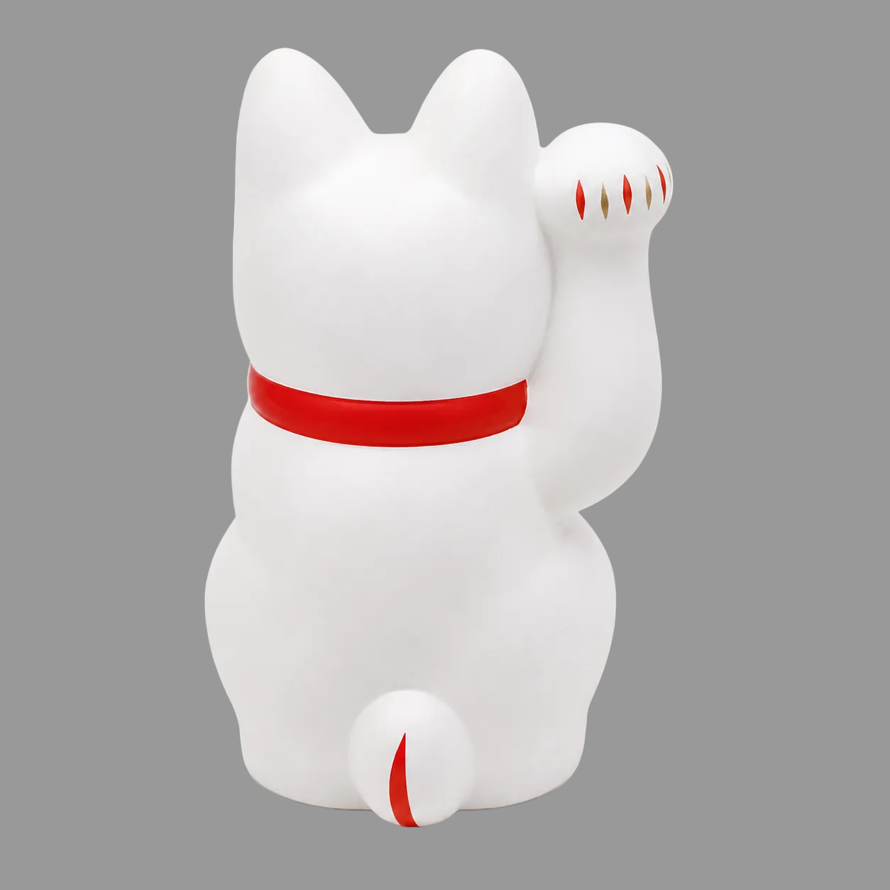 A white Japanese maneki-neko lucky cat figurine with a raised paw, featuring a bright red collar and small red and gold details on its paw and tail, set against a plain white background.